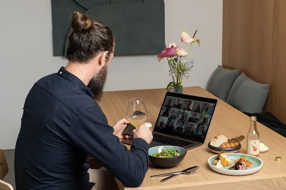 Medarbejder ved laptop med frokost fra A Treat på bordet