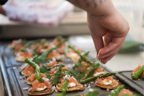 Påskefrokost med smørrebrød, rejer og æg på mørk stenplade