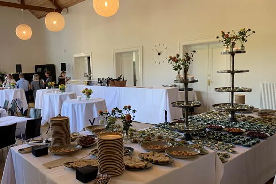 Reception i en lys sal med dækkede borde og buffet anrettet af A Treat