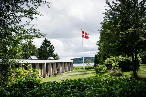 Ømborgen ved Mossø med dansk flag og grønne træer