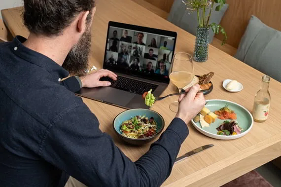 Medarbejder spiser frokost fra A Treat foran et videomøde med kolleger